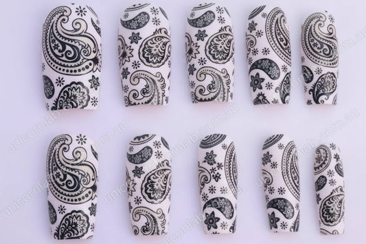 Black paisley patterned nails on a white background