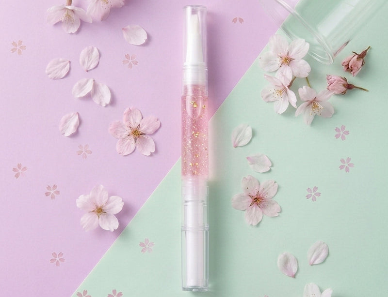 Pen with pink accents on a pastel green and purple background with cherry blossoms.