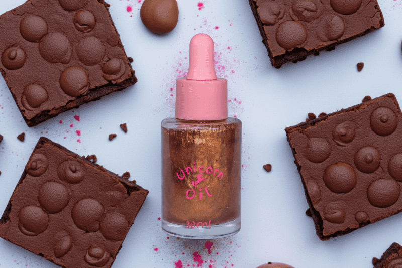 15ml glass dropper bottle of Chocolate Brownie Unicorn Cuticle Oil featuring golden shimmering oil and a professional label.