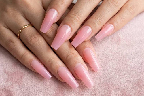 Close-up of hands with pink nail polish on a soft pink background