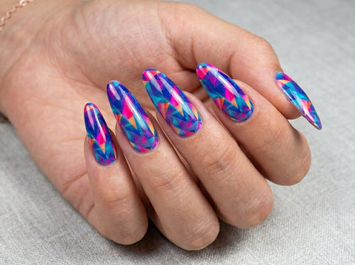 Hand with colorful nail art on a neutral background