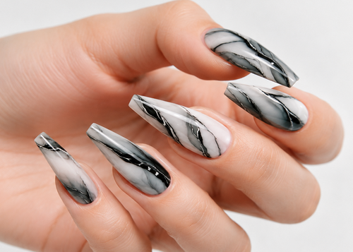 Hand with silver and white nail design on a light gray background