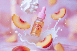 Unicorn oil bottle with peach slices and milk splash on a pink background