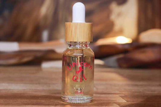 15ml glass bottle of organic Sandalwood Unicorn Cuticle Oil featuring a white dropper and clear, golden oil.