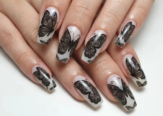 Nails with black butterfly designs on a white background