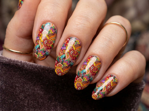 Close-up of a hand with colorful nail art on a blurred background