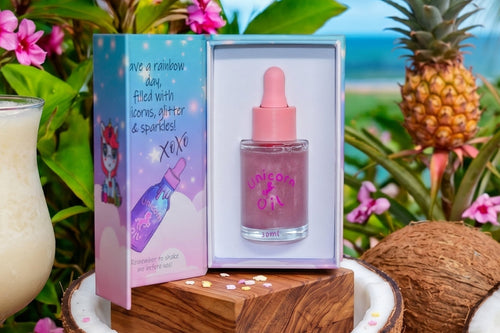 Pink bottle with dropper and packaging on a tropical setting with flowers and a pineapple.