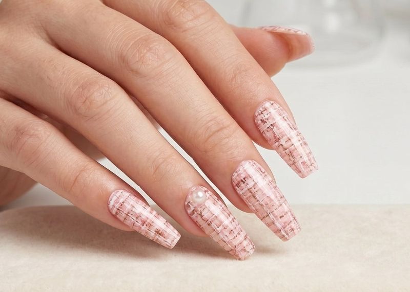 Hand with pink textured nails on a white surface. Soft Pink Tweed Waterslide nail Decals