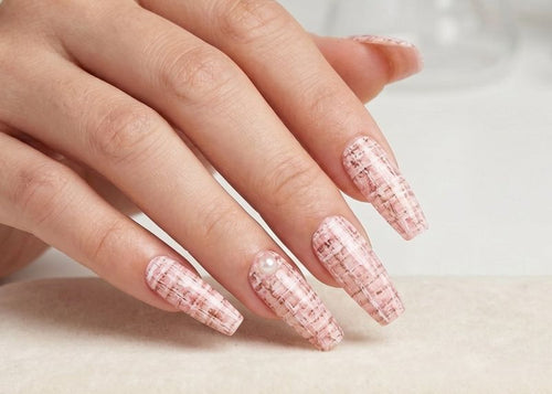 Hand with pink textured nails on a white surface. Soft Pink Tweed Waterslide nail Decals