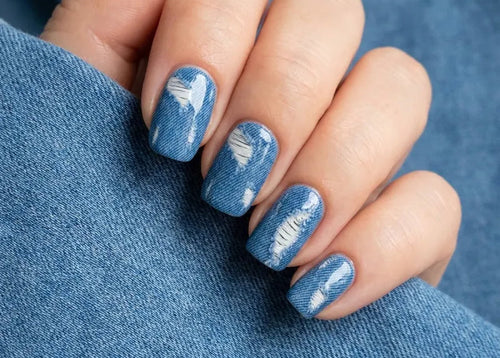 Nails with denim design on a blue fabric background