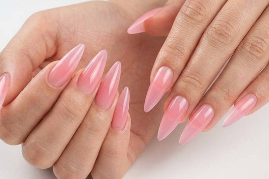 Close-up of hands with pink nail polish on a light background