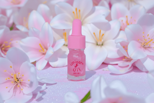Sugar Lily Unicorn Cuticle Oil - A soft scented nail serum with pink dropper in 5ml bottle surrounded by white and pink flowers