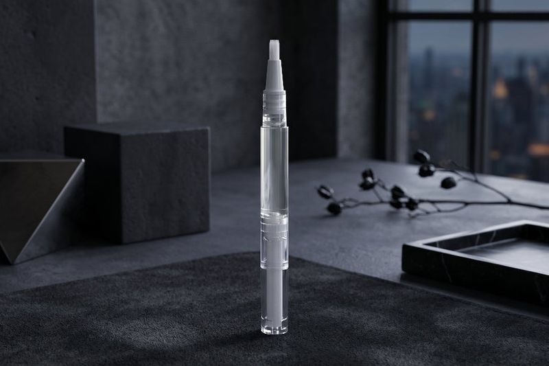 Clear cuticle oil pen for men on a dark surface with a cityscape in the background
