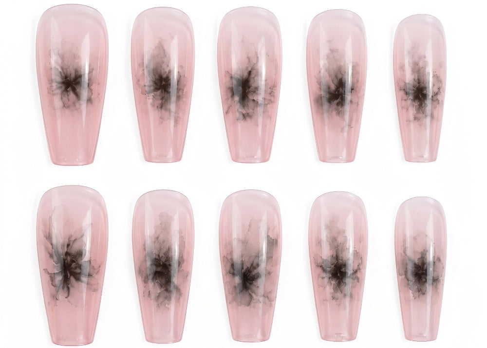 Set of pink press-on nails with black abstract designs on a white background