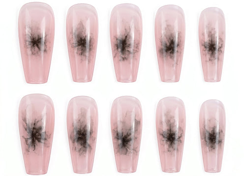 Set of pink press-on nails with black abstract designs on a white background