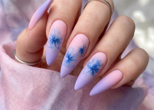 Nails with blue floral design on a light pink background