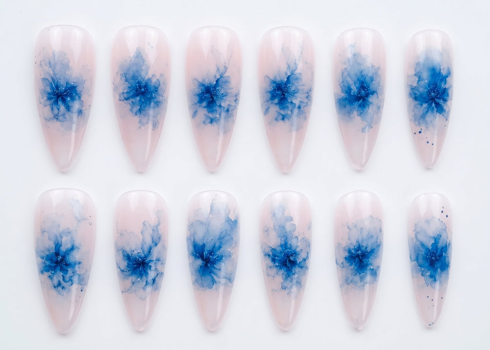 Nail art with blue abstract designs on a white background