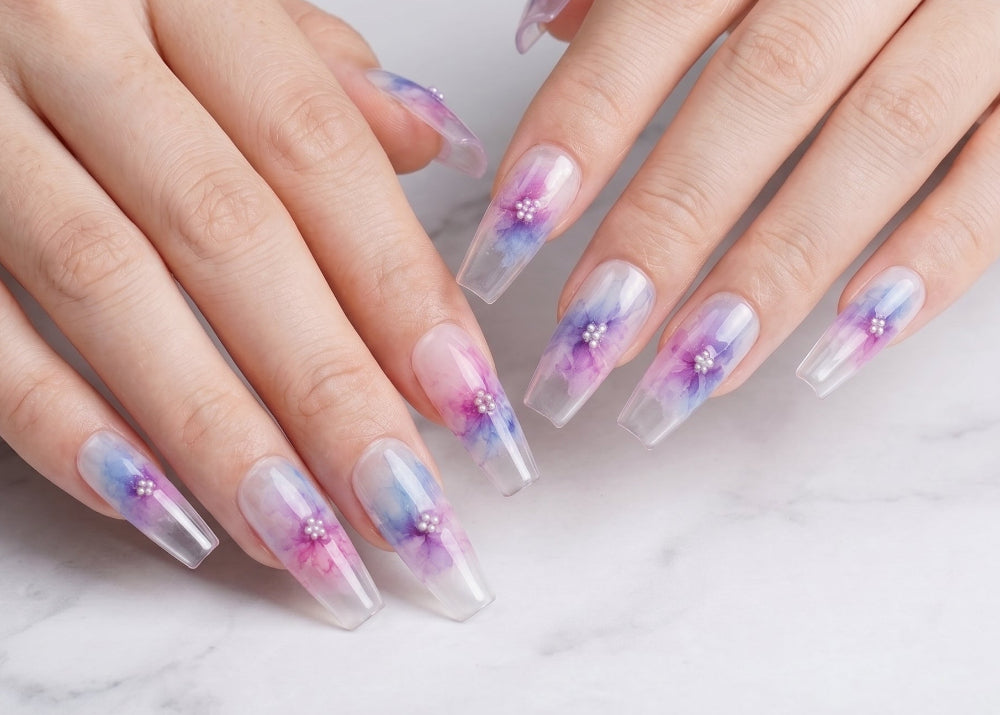 Close-up of hands with decorative nail art on a marble surface