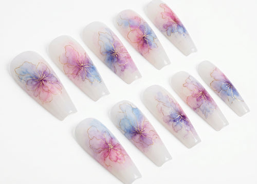 Set of press-on nails with floral designs on a white background