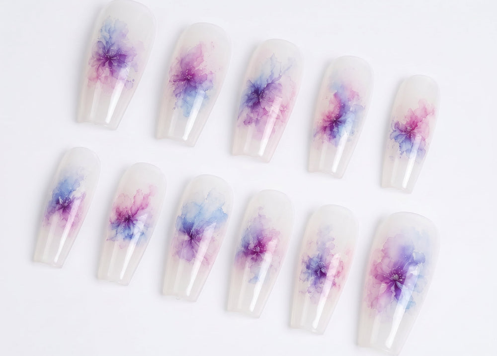 Nail art with watercolor flower designs on a white background