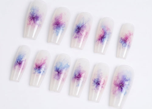 Nail art with watercolor flower designs on a white background