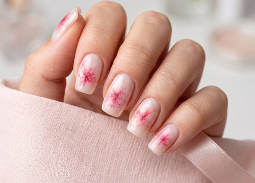 Close-up of a hand with pink floral nail design on a blurred background