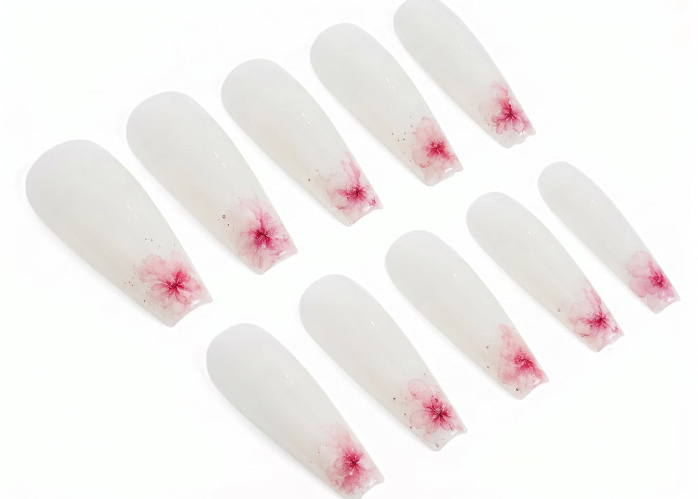 Set of white nail extensions with red floral patterns on a white background