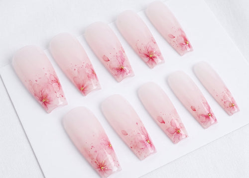 Set of press-on nails with cherry blossom design on a white background