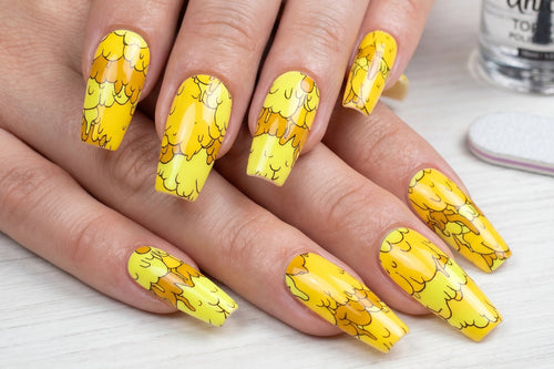 Nails with yellow nail art design on a light background