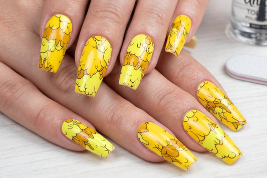 Nails with yellow nail art design on a light background