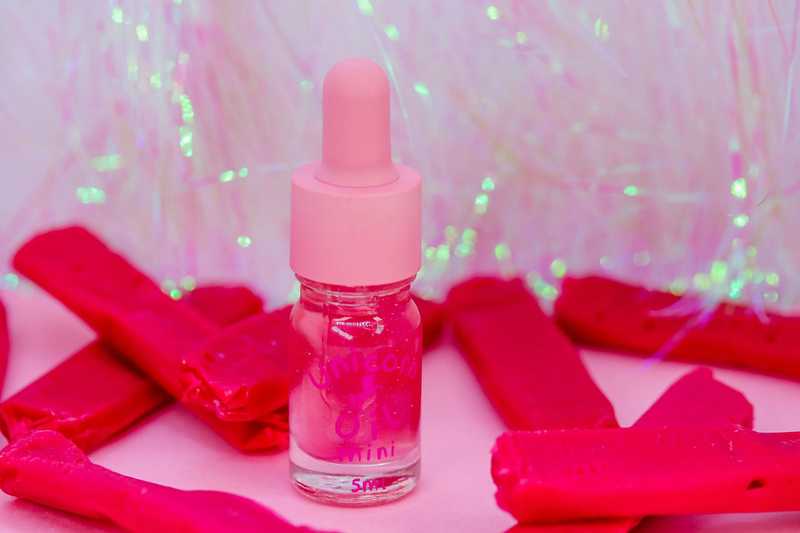 Red Skin scented cuticle oil surrounded by red candy, non-greasy nail serum for hydration