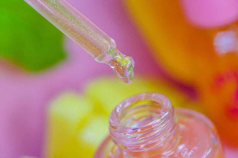 A detailed macro shot of Mango & Guava Unicorn Cuticle Oil - with shimmer oil dripping into bottle