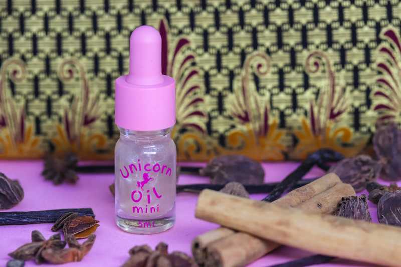 Vanilla Spice & Everything Nice Unicorn Cuticle Oil in a mini 5ml drpper bottle with pink cap. Standing in scene with star anise, cinnamon sticks and fresh vanilla pods to reflect fragrance notes.